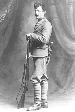 Boer War Photo, Private Harry Dougall Black of 2 RCRI poses for a studio shot with his Mark 1 Lee-Enfield rifle. Its bayonet can be seen suspended from the waistbelt over the left hip. CWM AN19710128-004