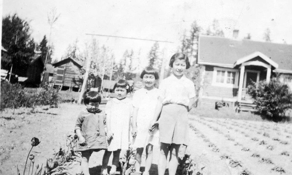 Image de quatre sœurs debout devant la maison