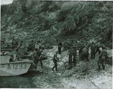 Prisonniers allemands déchargeant un engin de débarquement canadien, île du Levant