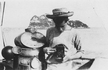 Marin coiffé d'un chapeau de paille et appareil-photo, NCSM Rainbow