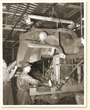 Des travailleurs montent un camion militaire dans une usine de la compagnie Ford du Canada Limitée à Windsor (Ont.), novembre 1940. - Photo :  Office national du film