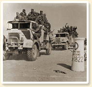 Truck-carried British infantry crosses the border of Tunisia. - AN19890223-037