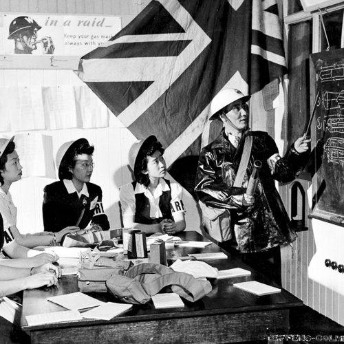 Cinq femmes canadiennes d'origine chinoise portant des brassards sont enseignés sur les différents types de bombes.