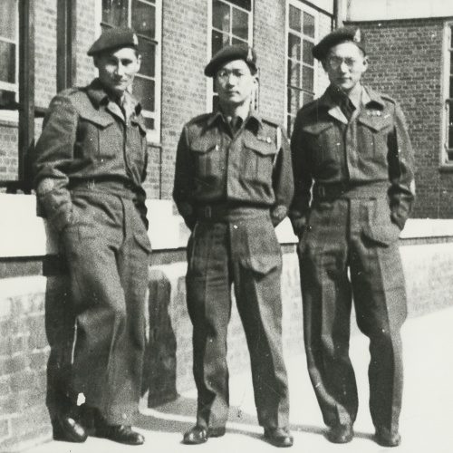 Trois professeurs de langue Canadiens japonais en uniformes de l'armée devant leur école.