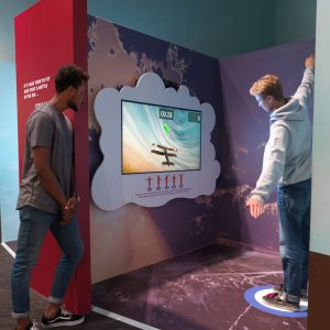 Un jeune homme utilise son corps pour naviguer un avion virtuel.