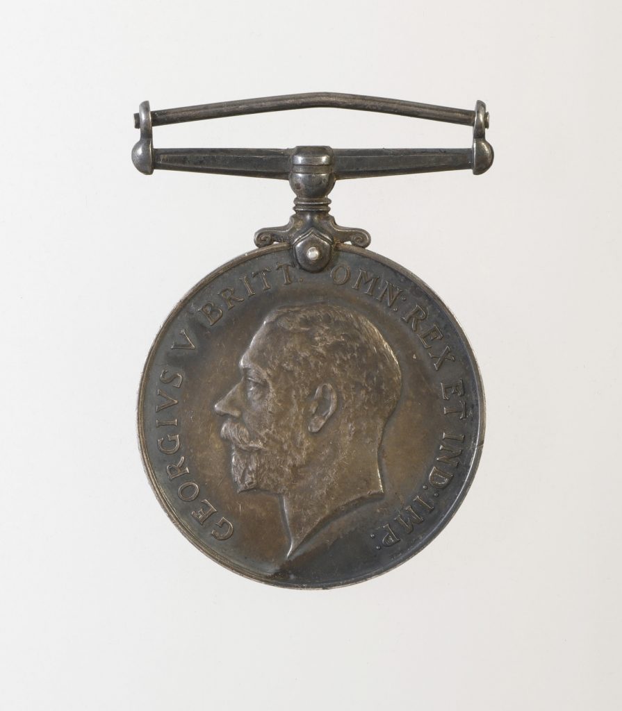 Une médaille circulaire en bronze gravée au profil du roi britannique George V.