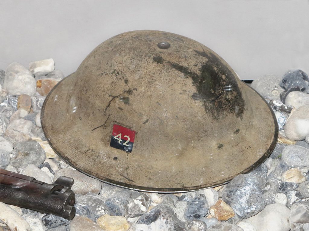 Un casque Mark II usé avec une petite marque distinctive peinte sur le côté, composée du numéro 42 sur un carré rouge et noir.