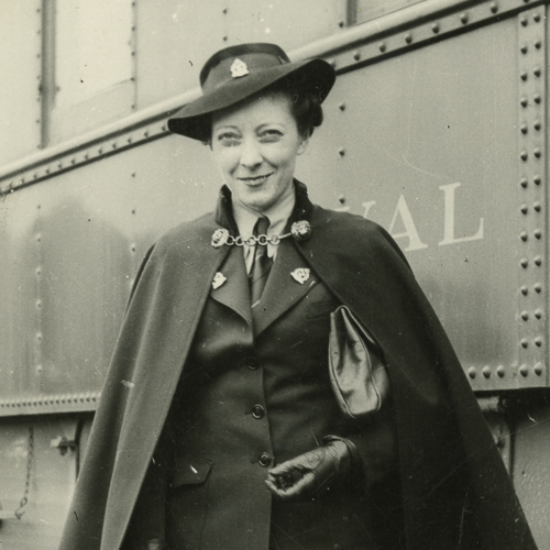 Une femme en cape debout à côté d’un train au Musée canadien de la guerre à Ottawa.