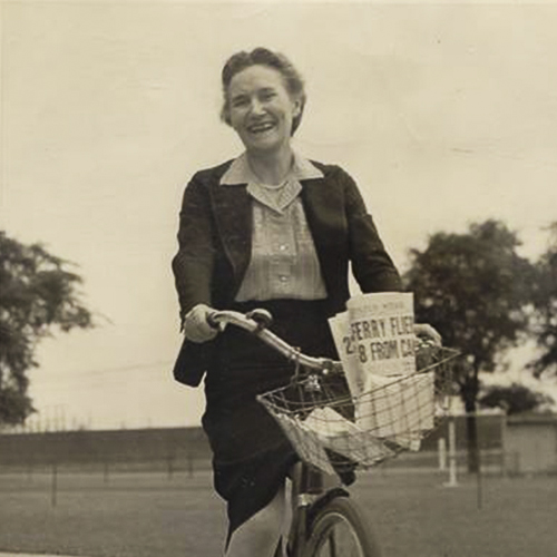 Une vieille photo d'une femme faisant du vélo avec un panier, exposée au Musée canadien de la guerre à Ottawa.