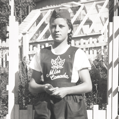 Une jeune fille en tablier debout devant une clôture au Musée canadien de la guerre à Ottawa.