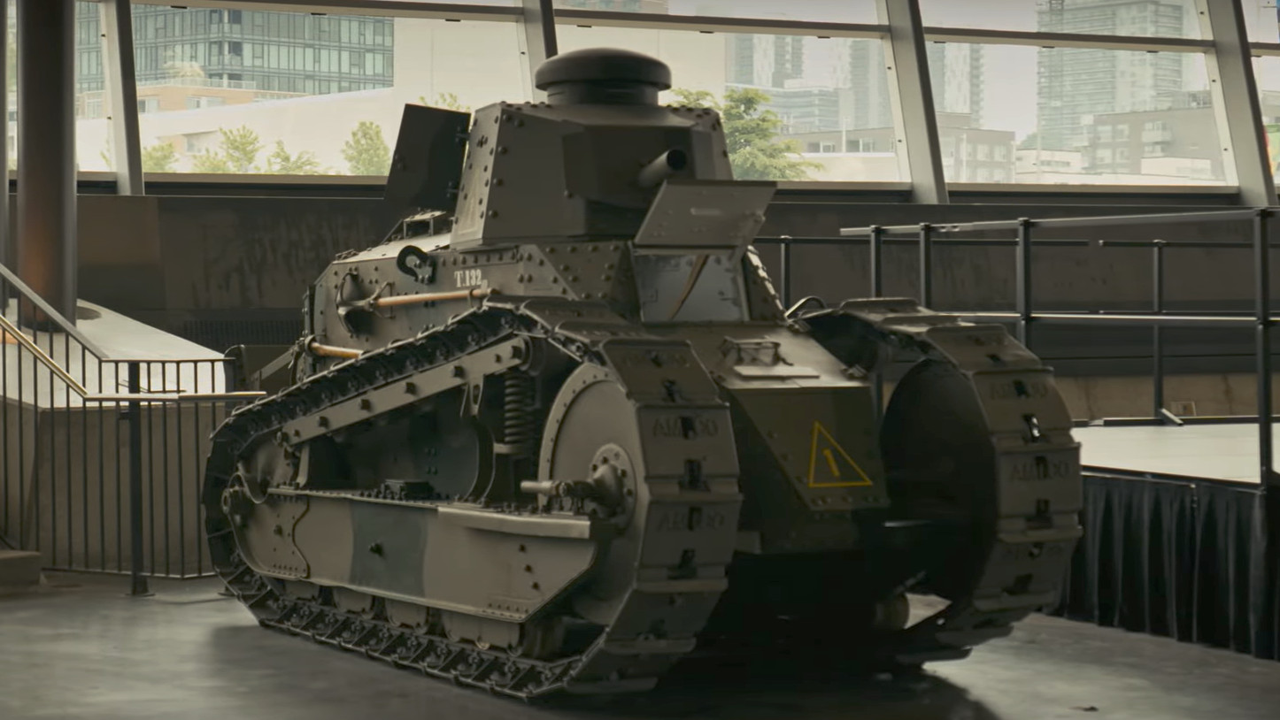 Petit char d’assaut militaire vert foncé avec de grandes chenilles.