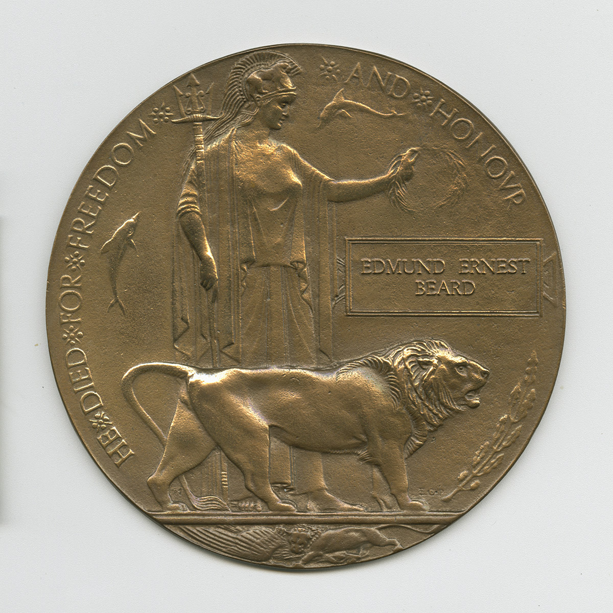 Médaillon en bronze représentant un soldat romain et un lion. Le médaillon porte le nom du soldat et la mention en anglais « Il est mort pour la liberté et l’honneur ».
