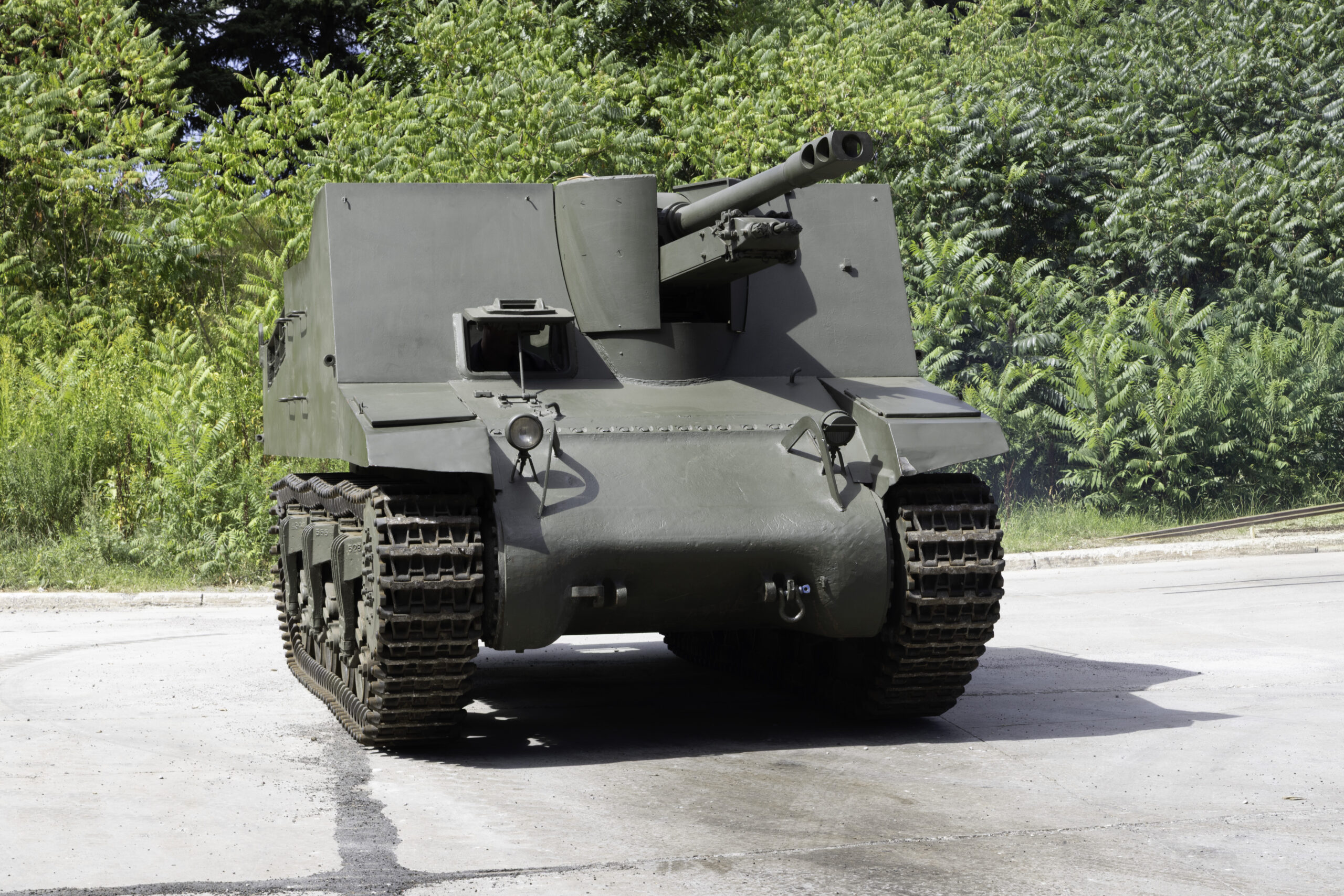 A green military tank with high, square armoured sides and a large forward-facing main gun.
