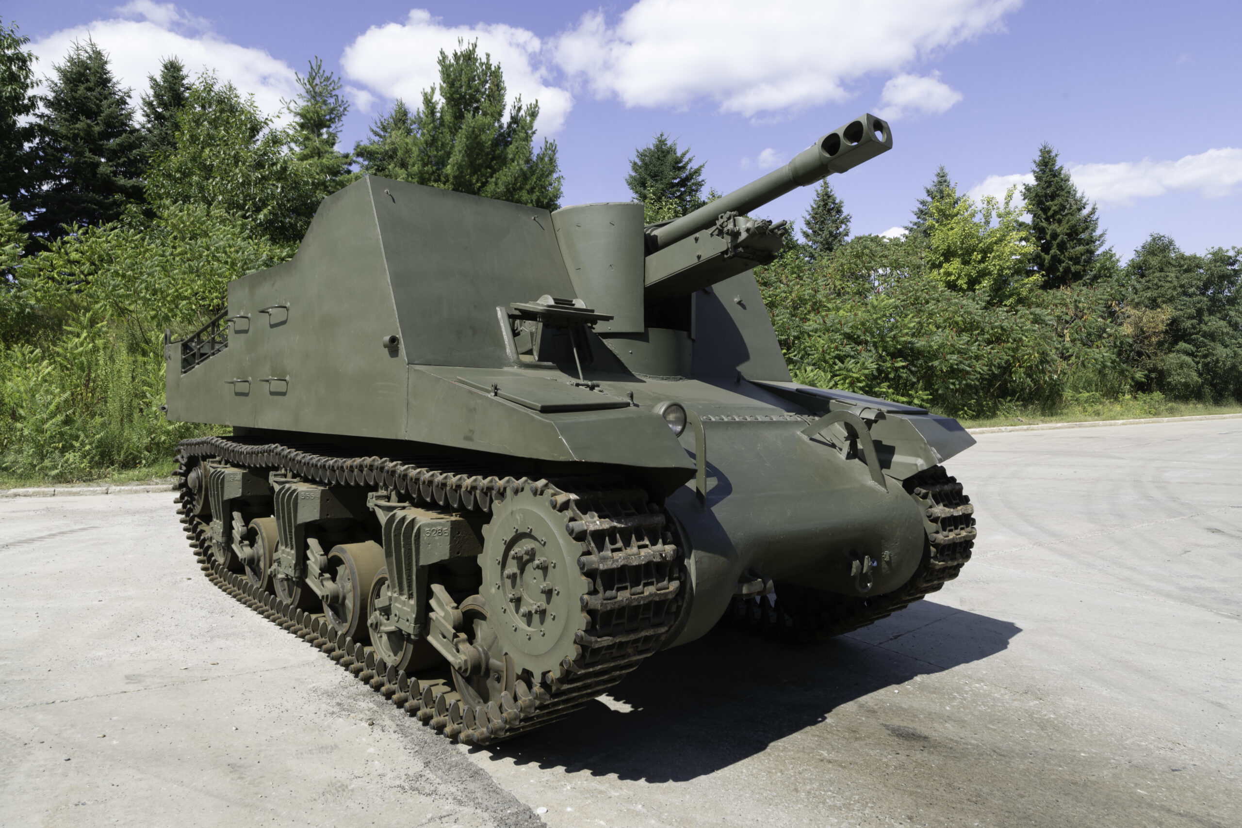 A green military tank with high, square armoured sides and a large forward-facing main gun.