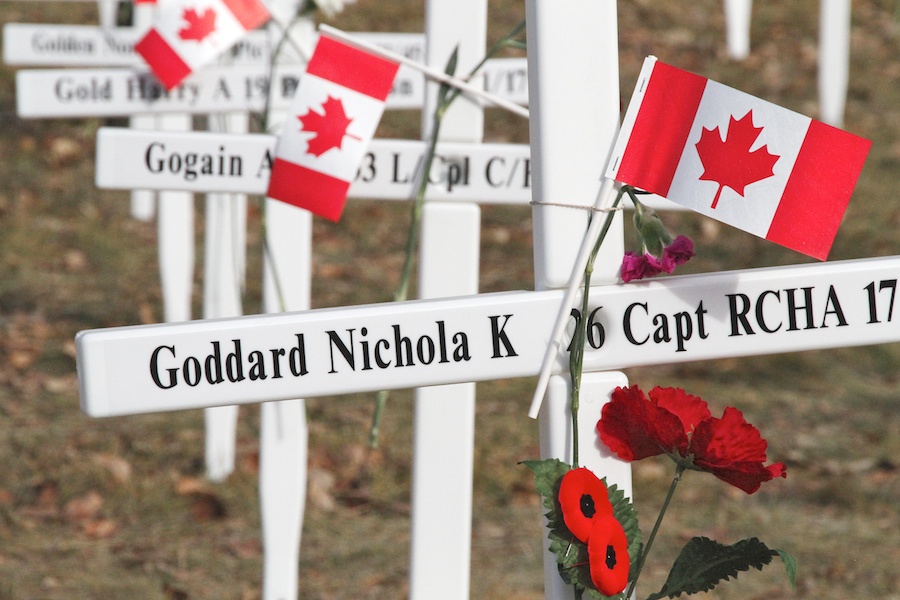 Une rangée de croix blanches ornées de coquelicots et de petits drapeaux canadiens. Sur la première, on peut lire « Goddard Nichola K 26, capitaine, RCHA 17 ».