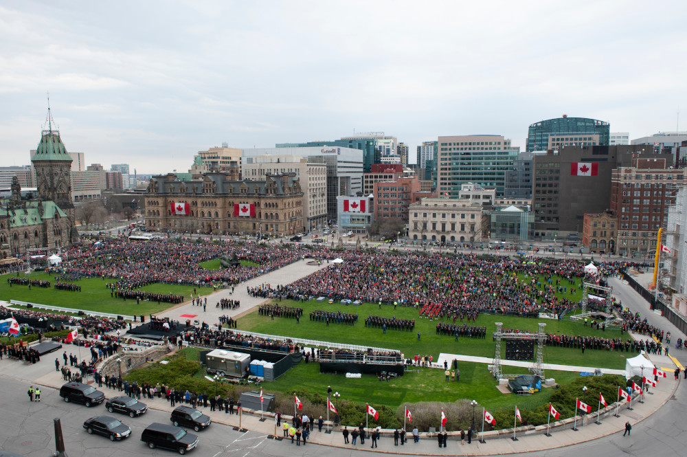 Vue d’en haut montrant une foule immense envahissant la pelouse de la colline du Parlement au Canada.
